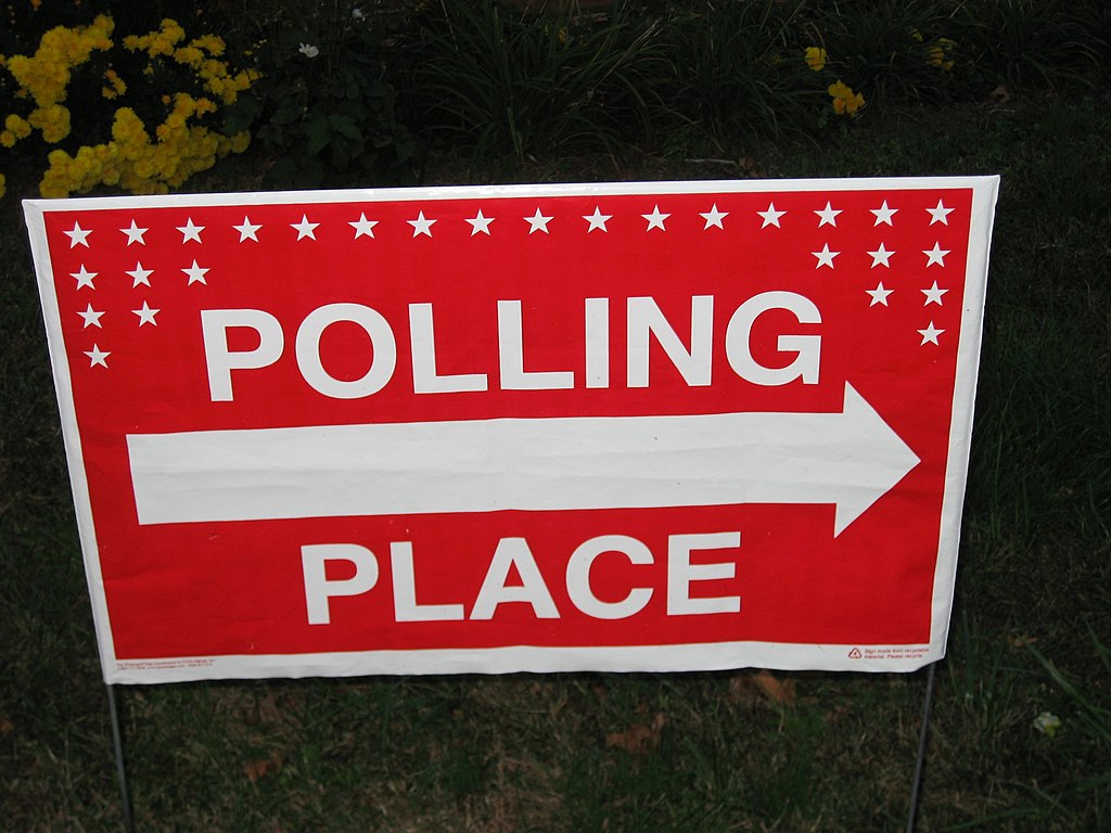 Image of a red sign with the words "Polling Place" a pointing arrow.